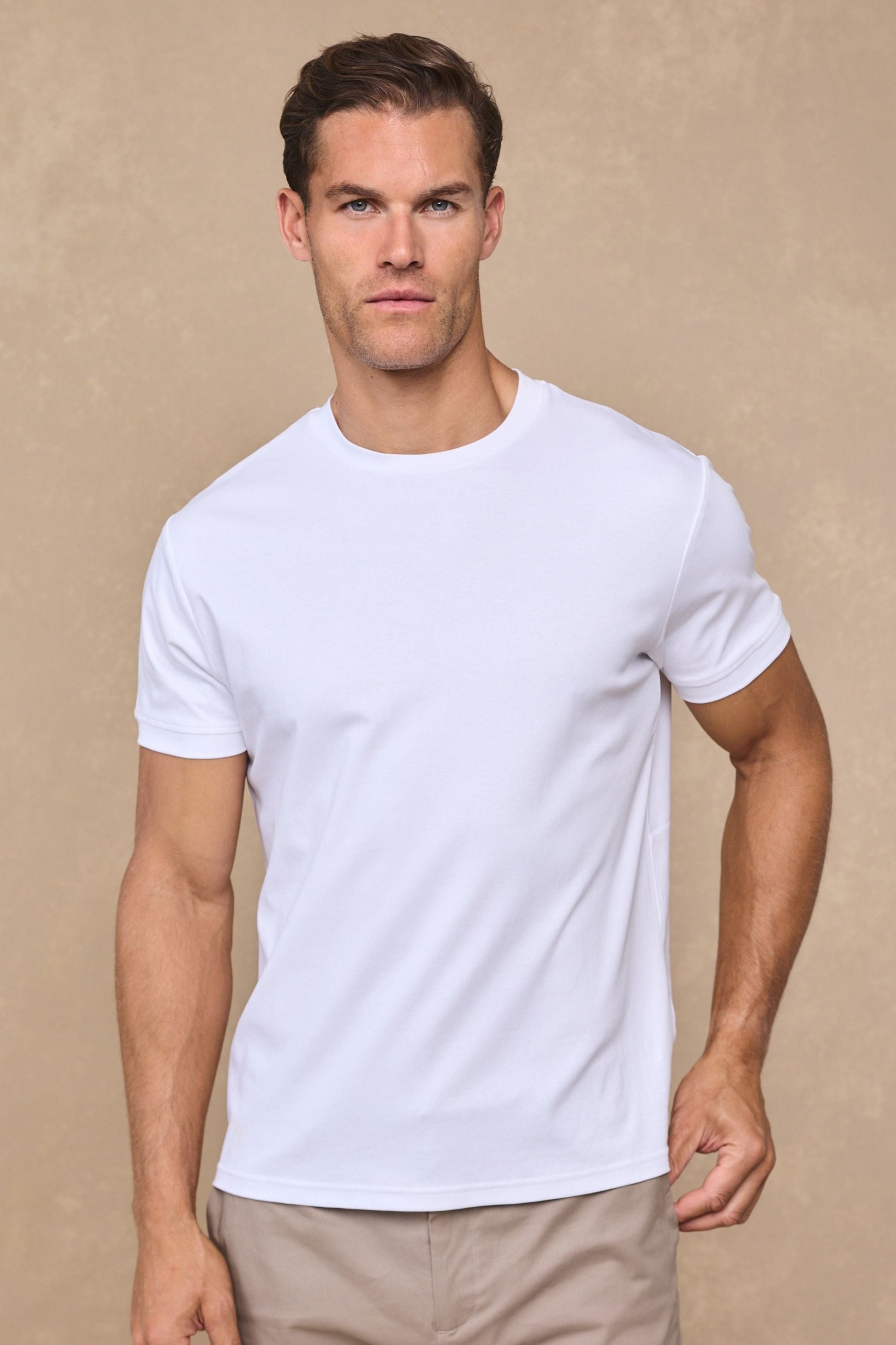 Man draagt het witte gemerceriseerde T-shirt in een ontspannen setting, de crew-neck kraag is duidelijk zichtbaar.