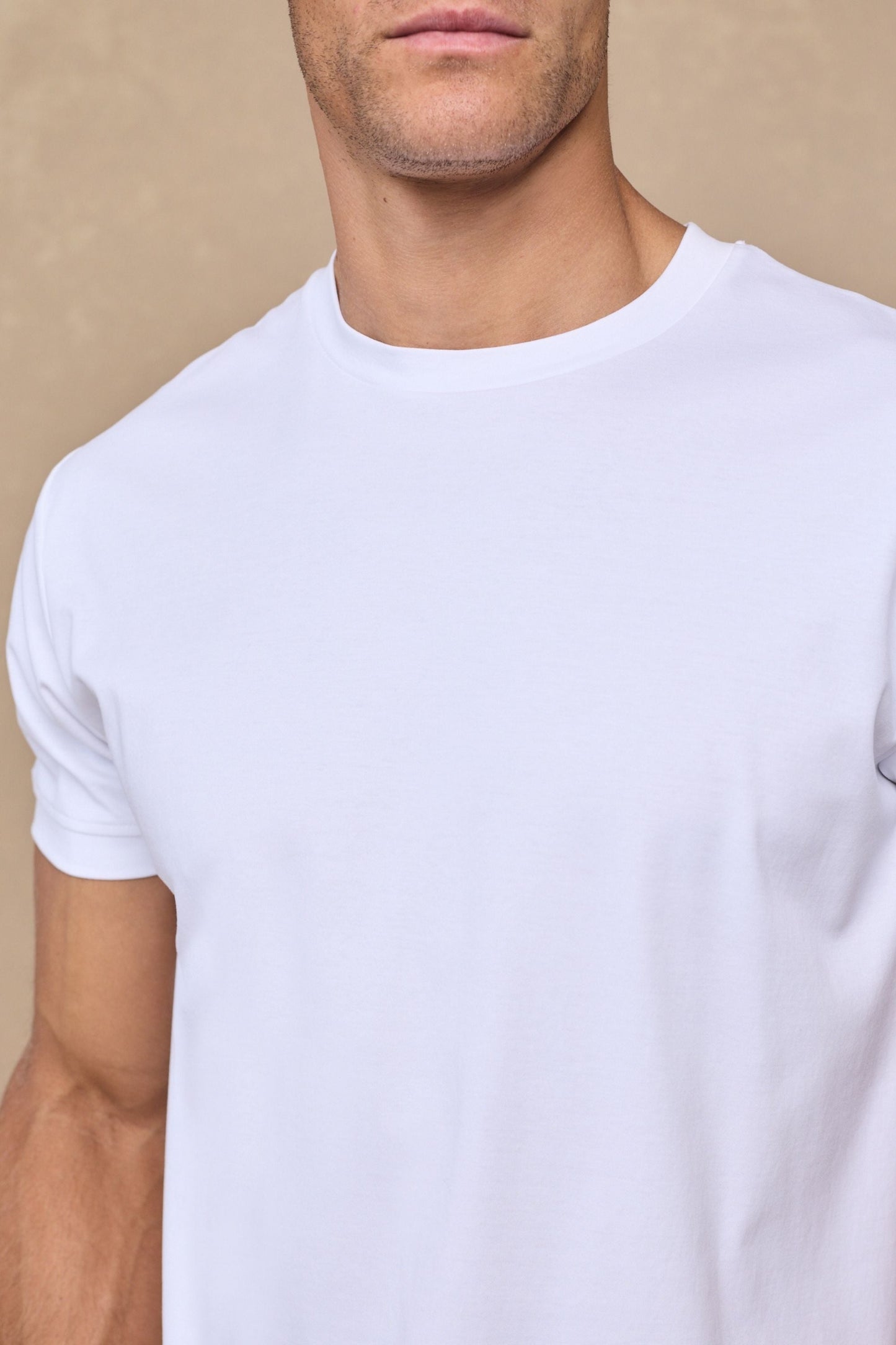 Achterkant van het witte gemerceriseerde T-shirt, toont de naadloze afwerking en de vloeiende drapering van de stof.