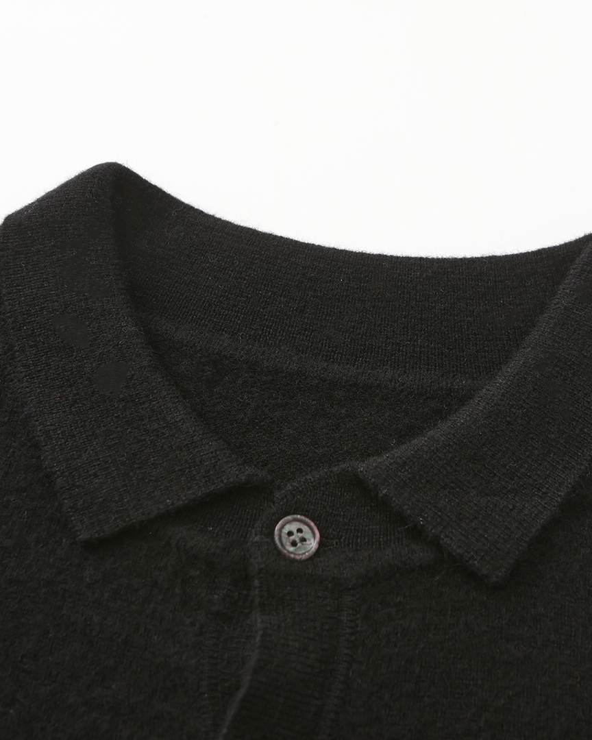 Close-up van de textuur en de kleurnuance van de beige kasjmier polo sweater, wat de luxe uitstraling bevestigt.