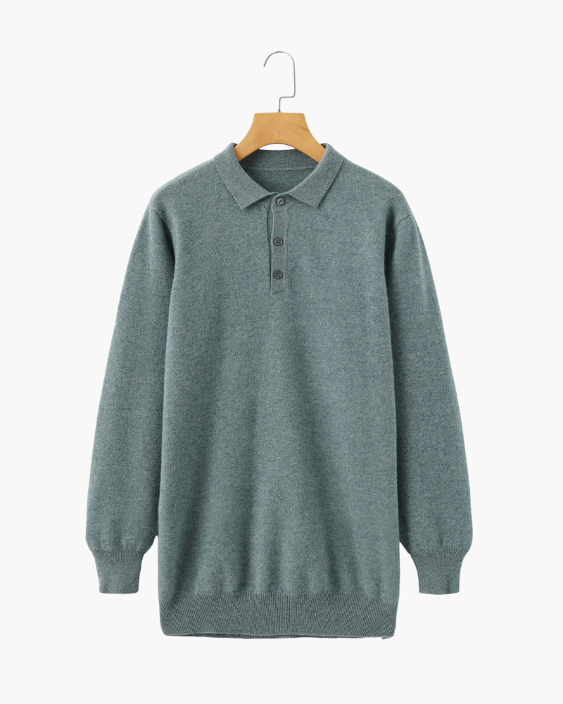 De lichtgrijze kasjmier polo sweater met een open kraag, wat een meer casual en ontspannen stijl suggereert.