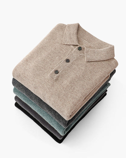 De groene kasjmier polo sweater, plat gelegd, toont de gelijkmatige breistructuur en de hoogwaardige afwerking van het kledingstuk.