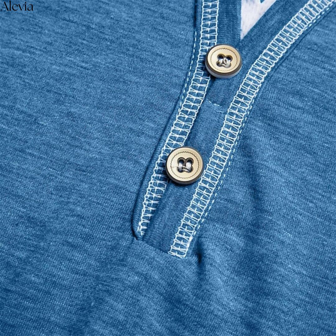 Een close-up van de subtiele V-hals en de knoopsluiting van het Finn T-shirt, met aandacht voor detail.