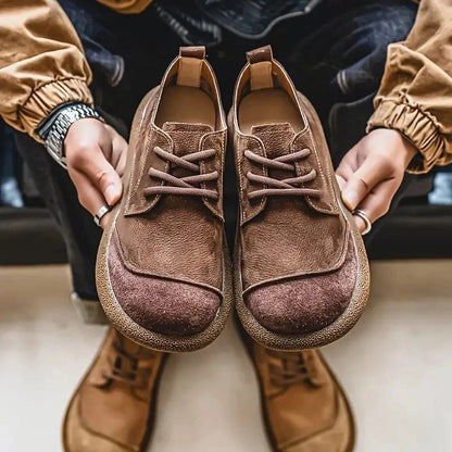 Gideon suède schoenen op een houten vloer, in een ontspannen setting die de veelzijdigheid benadrukt.