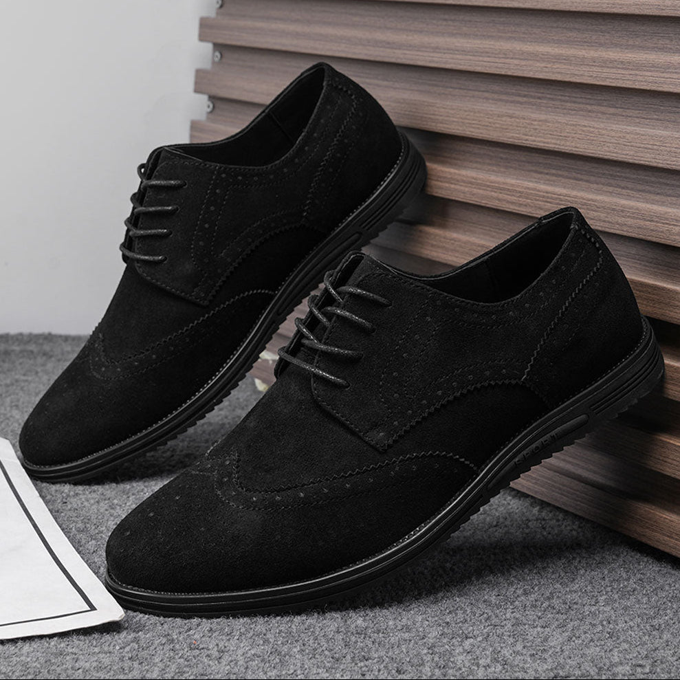 Gideon Derby schoenen in Blackout, rustend op een bankje in een park, benadrukt de casual elegantie.