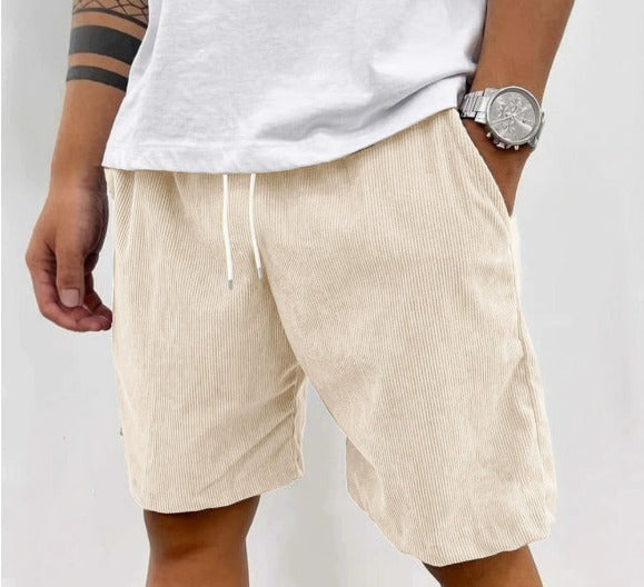 Mannelijk model draagt Gideon shorts in beige, zittend in een ontspannen houding