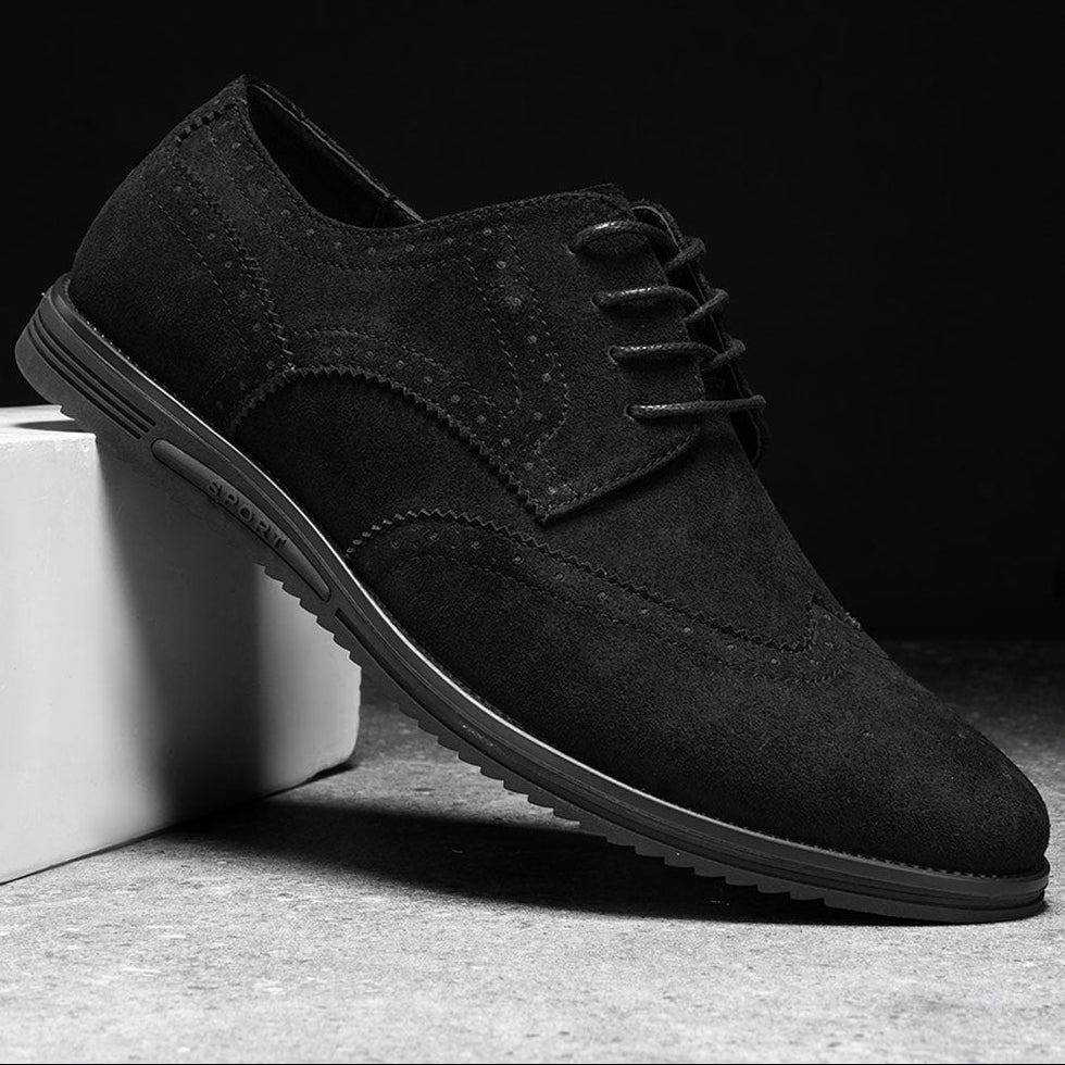Man die de British Tan Gideon Derby schoenen past in een schoenenwinkel, toont de diverse maatopties.