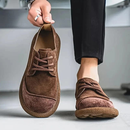 Detailopname van het zachte suède-effect materiaal van de lichtbruine Gideon schoenen.