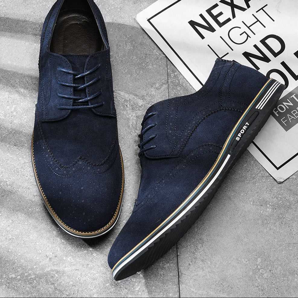 Gideon Derby schoenen in British Tan, gedragen door een man die staat, toont de pasvorm en het draagcomfort.