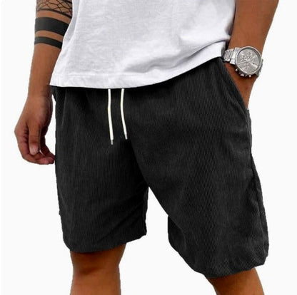 Mannelijk model toont de veelzijdigheid van de zwarte Gideon shorts tijdens een wandeling