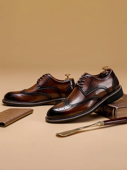Zwarte Wingtip Brogue herenschoenen met glanzende afwerking, getoond in een professionele studio-opstelling voor een strakke look.