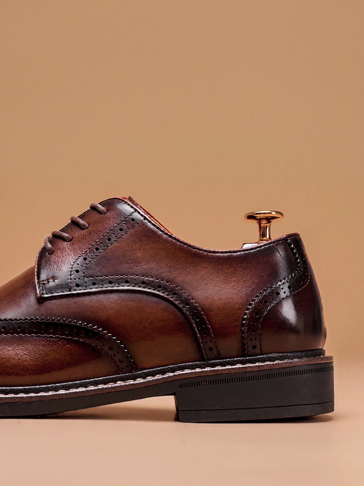 Gedetailleerde weergave van de antislip rubberen zool en de hand-burnished finish van de zwarte Wingtip Brogue herenschoenen.