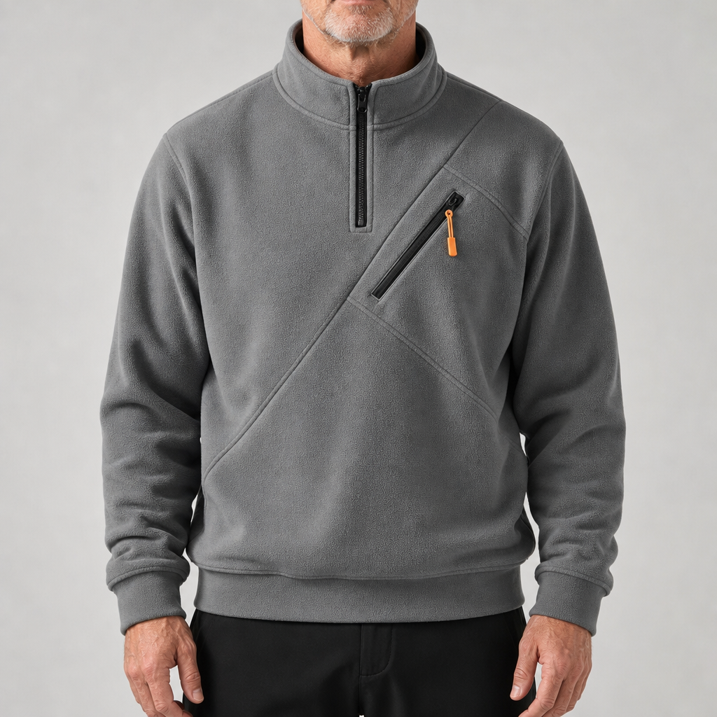 De donkerblauwe sweater, van voren gezien, toont de praktische borstzak met oranje trekker.