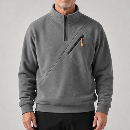 De donkerblauwe sweater, van voren gezien, toont de praktische borstzak met oranje trekker.