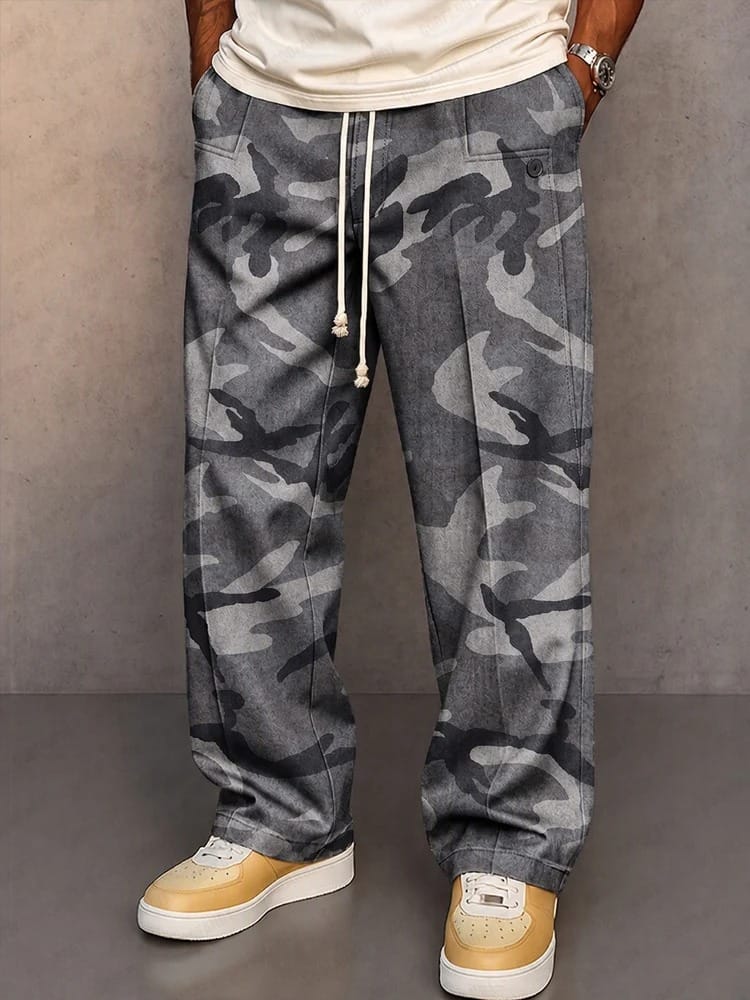 Zijaanzicht van de relaxte pasvorm van de camouflage broek, met aandacht voor de ruime functionele zakken aan de zijkant.