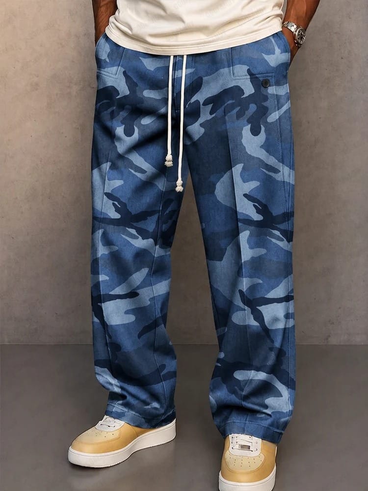 Een man draagt de grijze camouflage broek in een stedelijke omgeving, casual gestyled met een effen T-shirt.