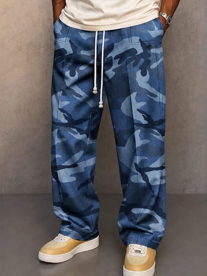 Een man draagt de grijze camouflage broek in een stedelijke omgeving, casual gestyled met een effen T-shirt.
