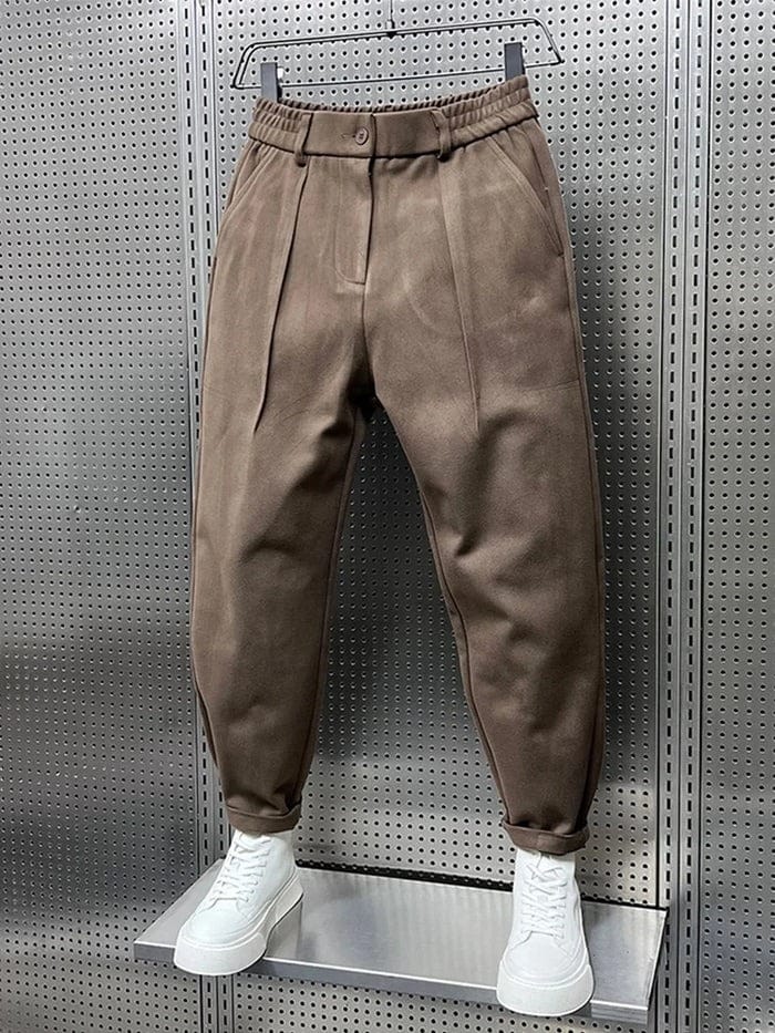 Achterkant van de bruine getailleerde broek, met zicht op de nette afwerking en de elastische tailleband.