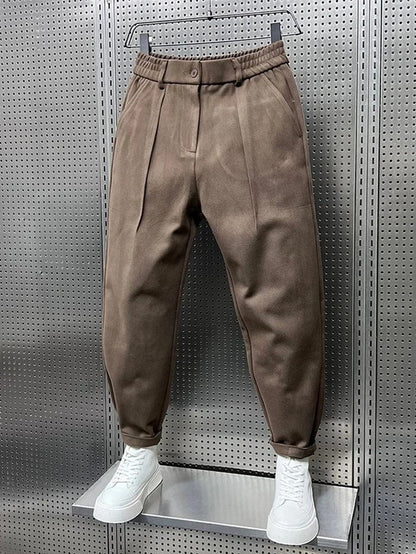Achterkant van de bruine getailleerde broek, met zicht op de nette afwerking en de elastische tailleband.