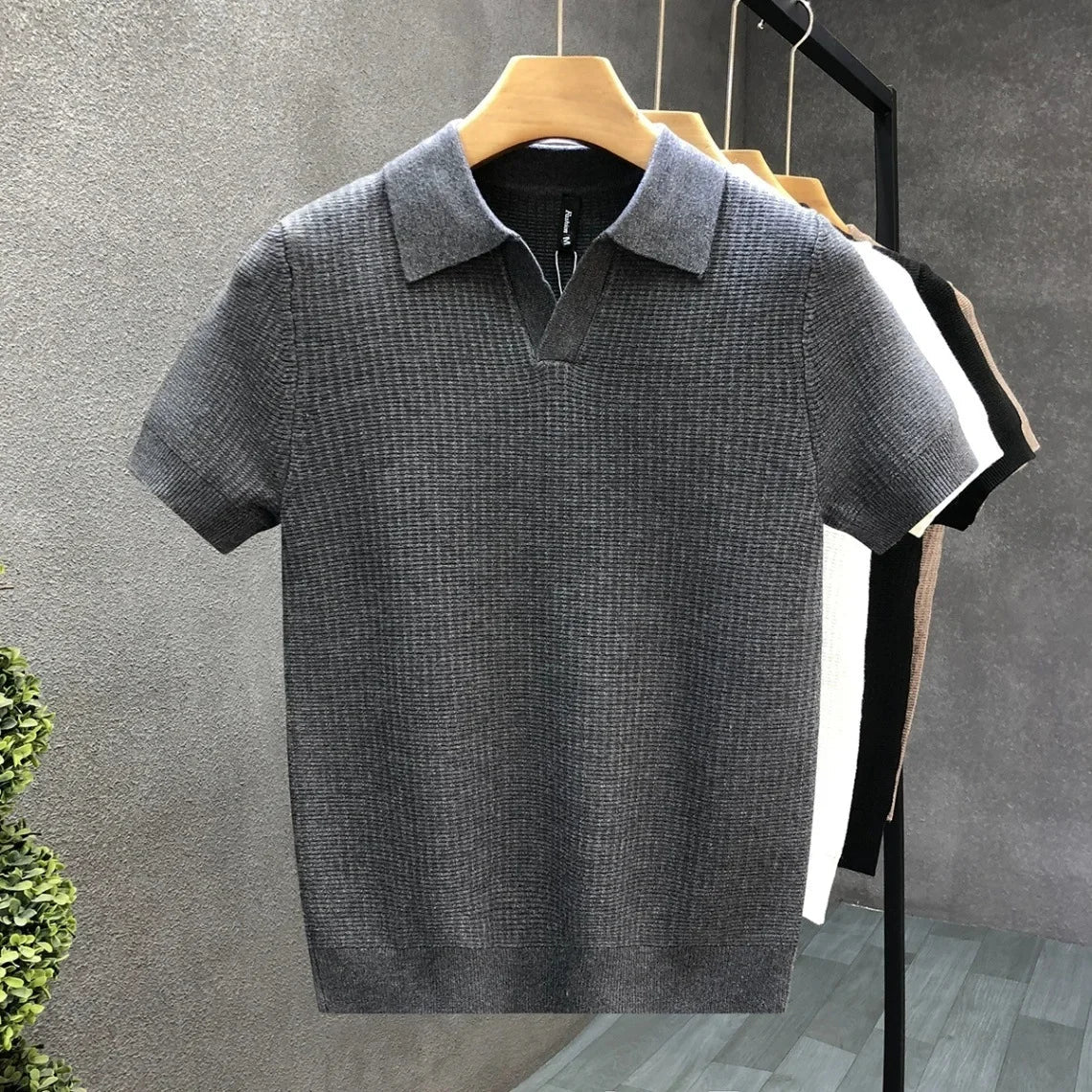 Een man draagt het Jasper ademende gebreide poloshirt in een casual setting, gecombineerd met een spijkerbroek.