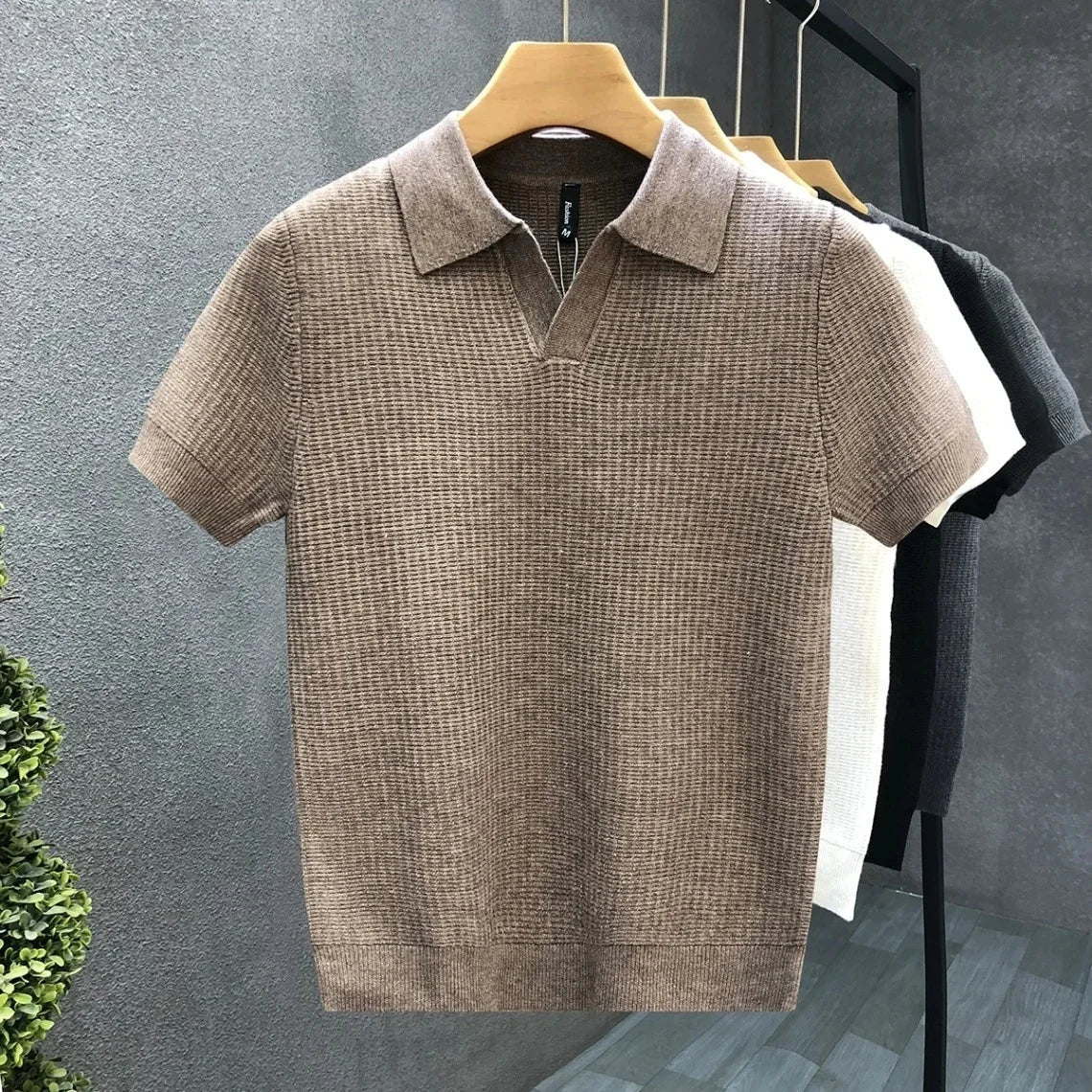 Het Jasper ademende gebreide poloshirt in grijs, gedragen door een model in een smart-casual pose.