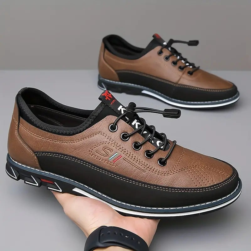 Een man die zijn caramelkleurige vegan Oxford schoenen toont terwijl hij zit, met een lichte broek.