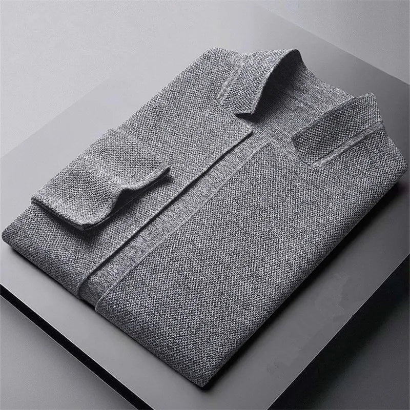 Zijaanzicht van de man in het grijze cardigan, die de soepele valling en moderne stijl benadrukt.