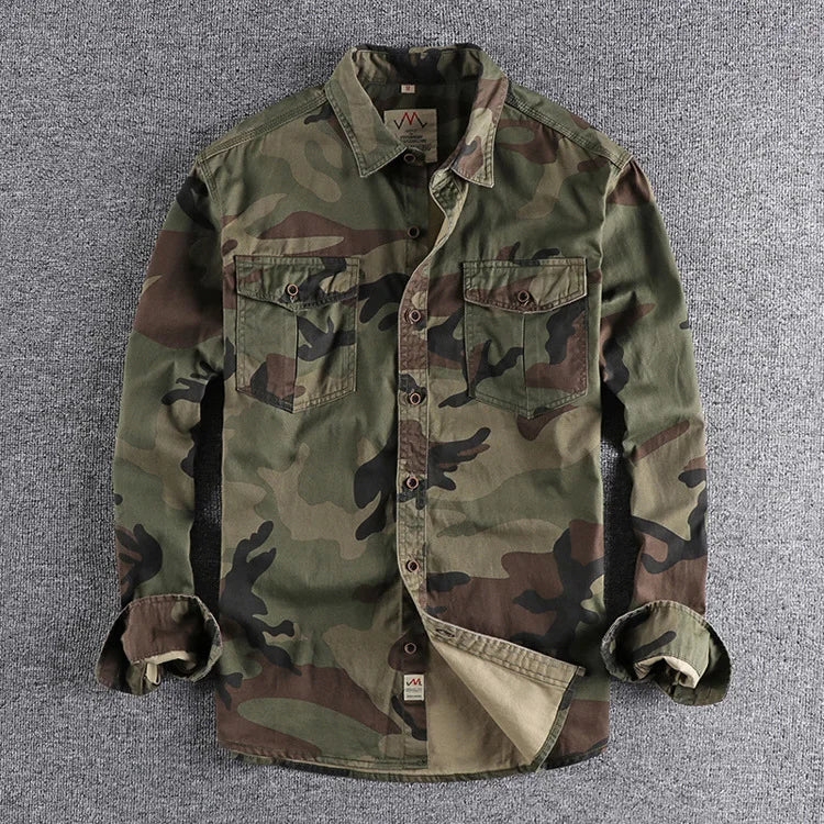 Close-up van de dubbele borstzakken op het camouflage T-shirt, met aandacht voor de stiksels en de knoopsluiting.