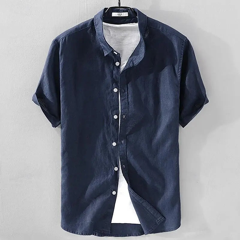 Zijaanzicht van een man die het Julius overhemd met korte mouwen draagt, casual gestyled met een broek, in een ontspannen houding.