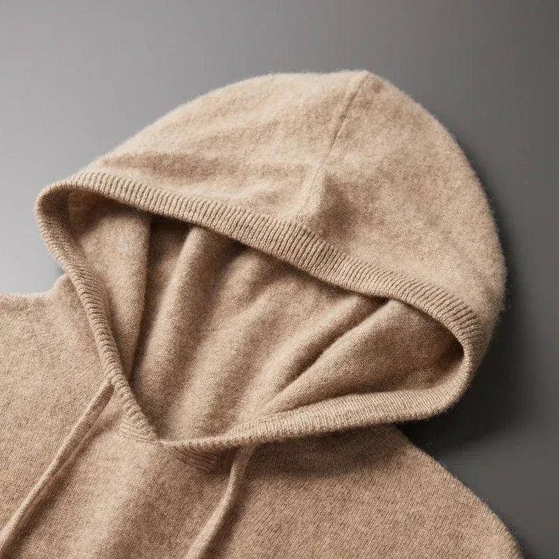 Zijaanzicht van de grijze merinowollen hoodie, met focus op de soepele drape en geribbelde zoom.