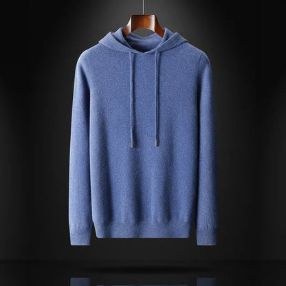 Man draagt een zwarte merinowollen hoodie onder een jas, toont de veelzijdigheid als tussenlaag.