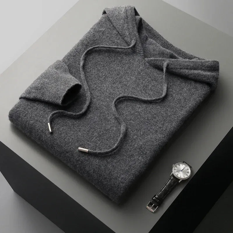 Man poseert casual in een grijze merinowollen hoodie, toont comfort en bewegingsvrijheid.