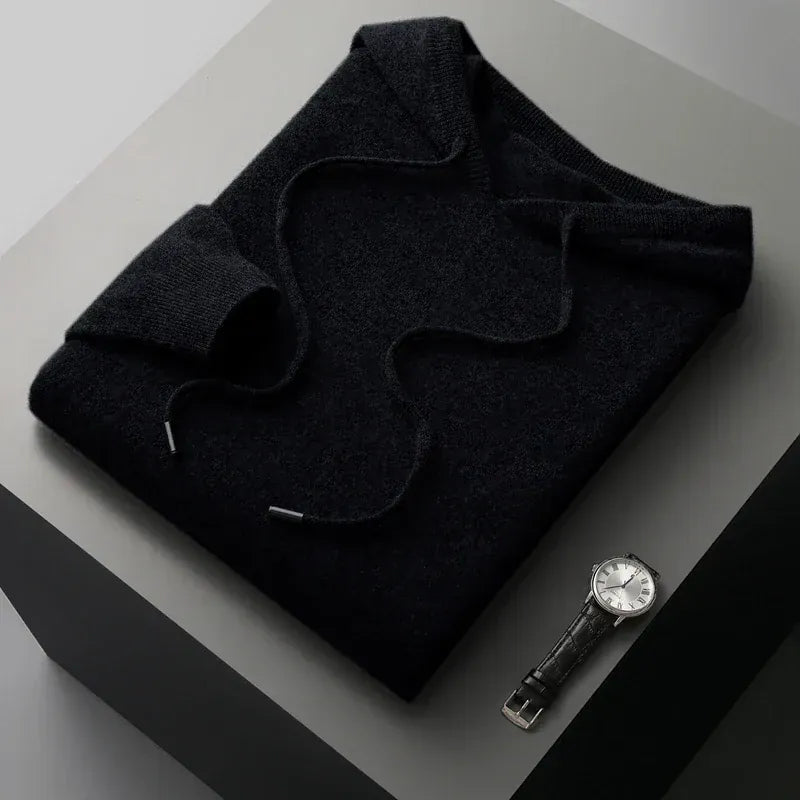 Close-up van de geribbelde manchet van de zwarte merinowollen hoodie, met aandacht voor detail.