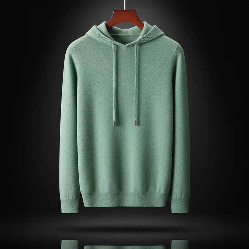 De oat-kleurige merinowollen hoodie liggend plat, benadrukt de kwaliteit van het materiaal.