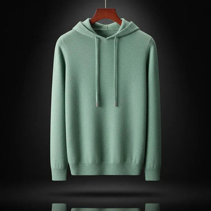 De oat-kleurige merinowollen hoodie liggend plat, benadrukt de kwaliteit van het materiaal.