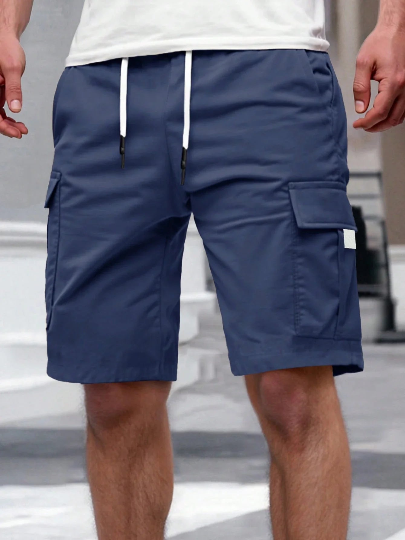Model wandelt ontspannen langs het strand, draagt de witte Lennart cargoshorts.