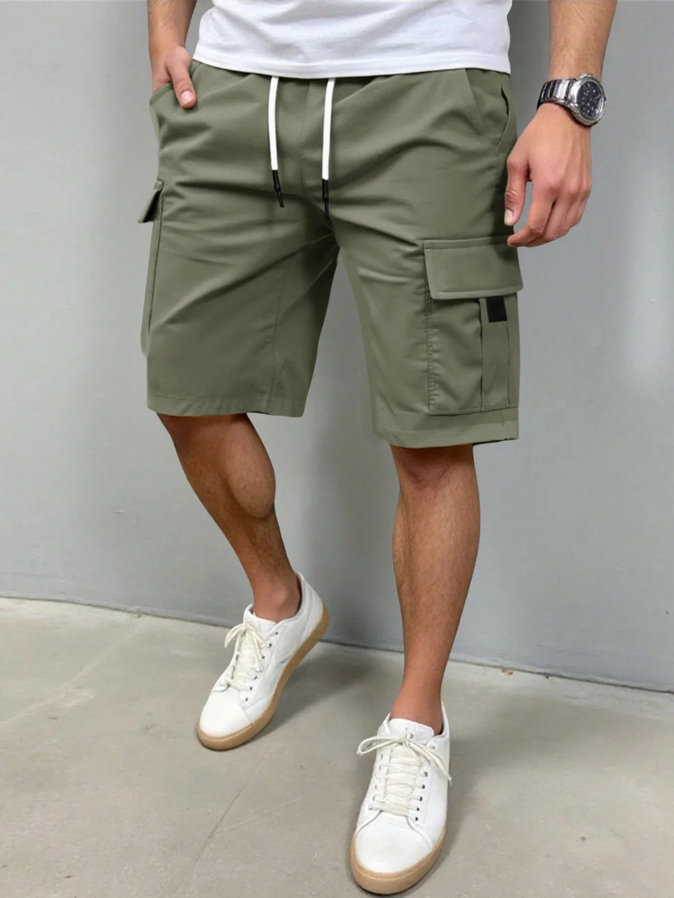 Model zittend op een bankje, draagt de grijze Lennart cargoshorts en geniet van het comfort.