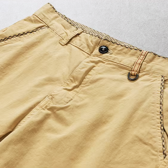 Close-up van de voorzakken van de bordeauxrode katoenen chino shorts, functioneel en stijlvol.
