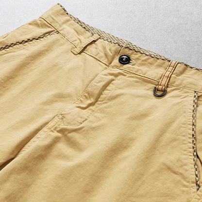 Close-up van de voorzakken van de bordeauxrode katoenen chino shorts, functioneel en stijlvol.