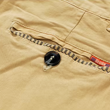 Een man zit ontspannen en draagt de khaki Lennox katoenen chino shorts, genietend van een vrije dag.