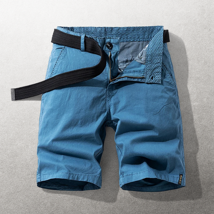 Detailopname van de tailleband en knoopsluiting van de blauwe katoenen chino shorts.