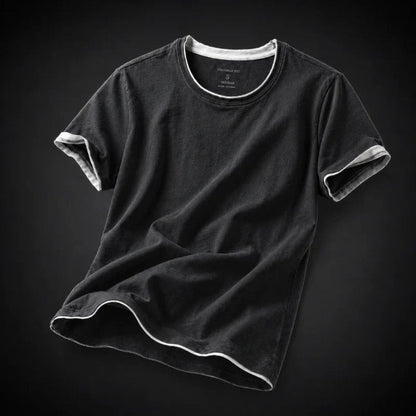 Grijs Lennox katoenen T-shirt in een lifestyle setting, gedragen tijdens een ontspannen wandeling langs de kust.