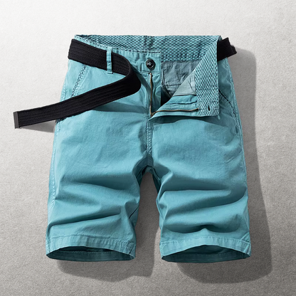 Een stapel van verschillende gekleurde Lennox katoenen chino shorts: khaki, blauw, groen, bordeaux en teal.