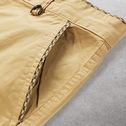 Detail van de rits en de verwijderbare webriem van de groene katoenen chino shorts, duidelijk zichtbaar.