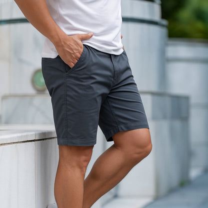 Een man draagt de Loris katoenen shorts in een lichte kleur, staand op een zonnige locatie, casual gestyled.