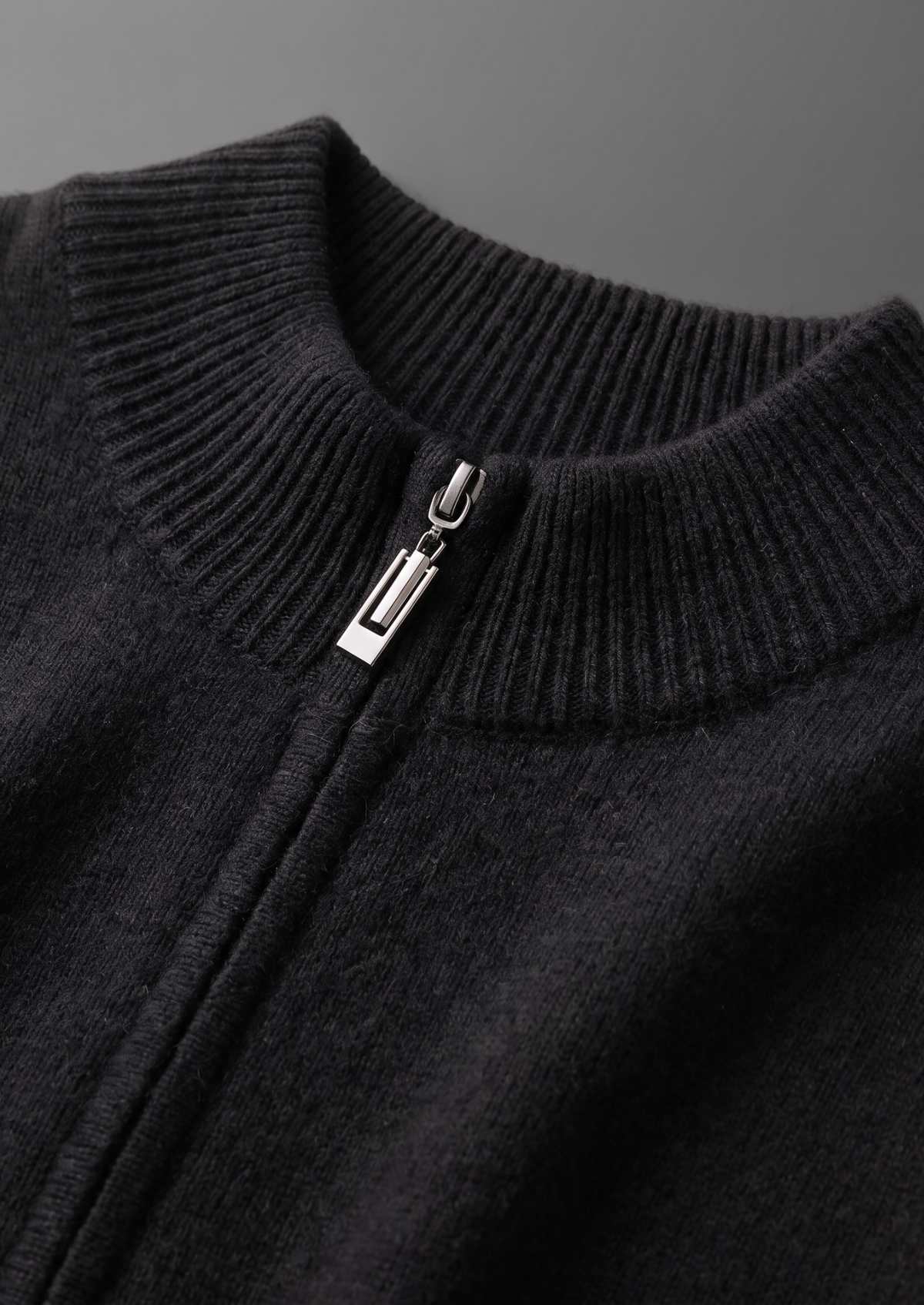 Detail van de subtiele en verfijnde textuur van de gebreide Merino wollen sweater.