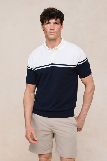 Zijprofiel van het gestreepte gebreide poloshirt, toont de comfortabele pasvorm en de zachte textuur.