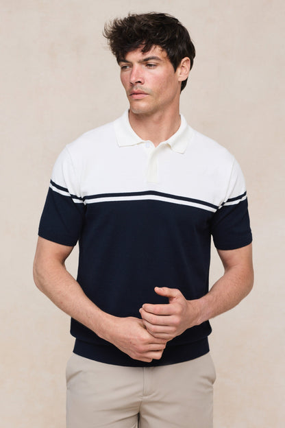 Man draagt het gebreide poloshirt in een ontspannen setting, benadrukt de veelzijdigheid en stijl.