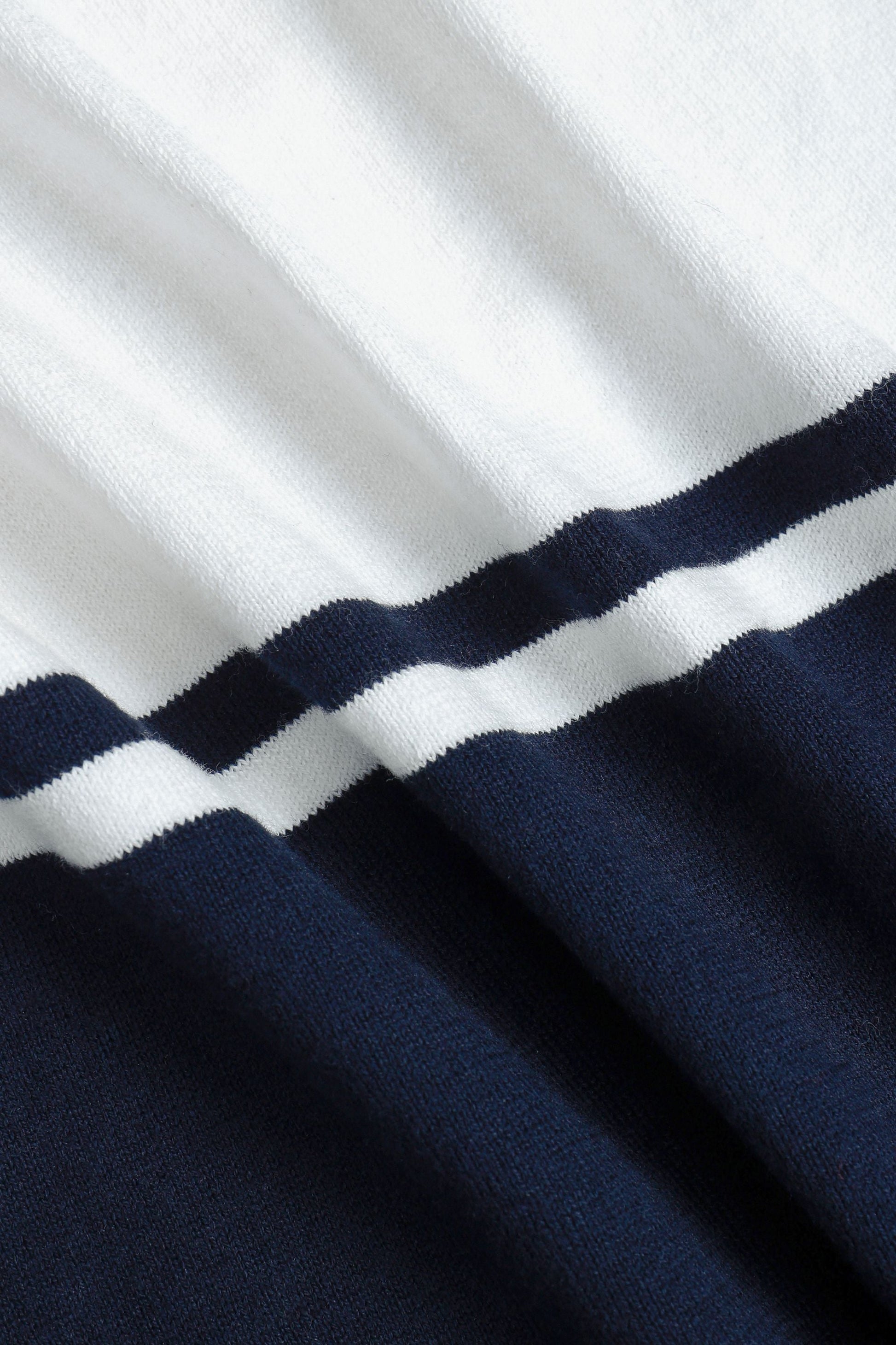 Detailopname van de korte mouw en de afwerking van het gebreide poloshirt, toont de kwaliteit.
