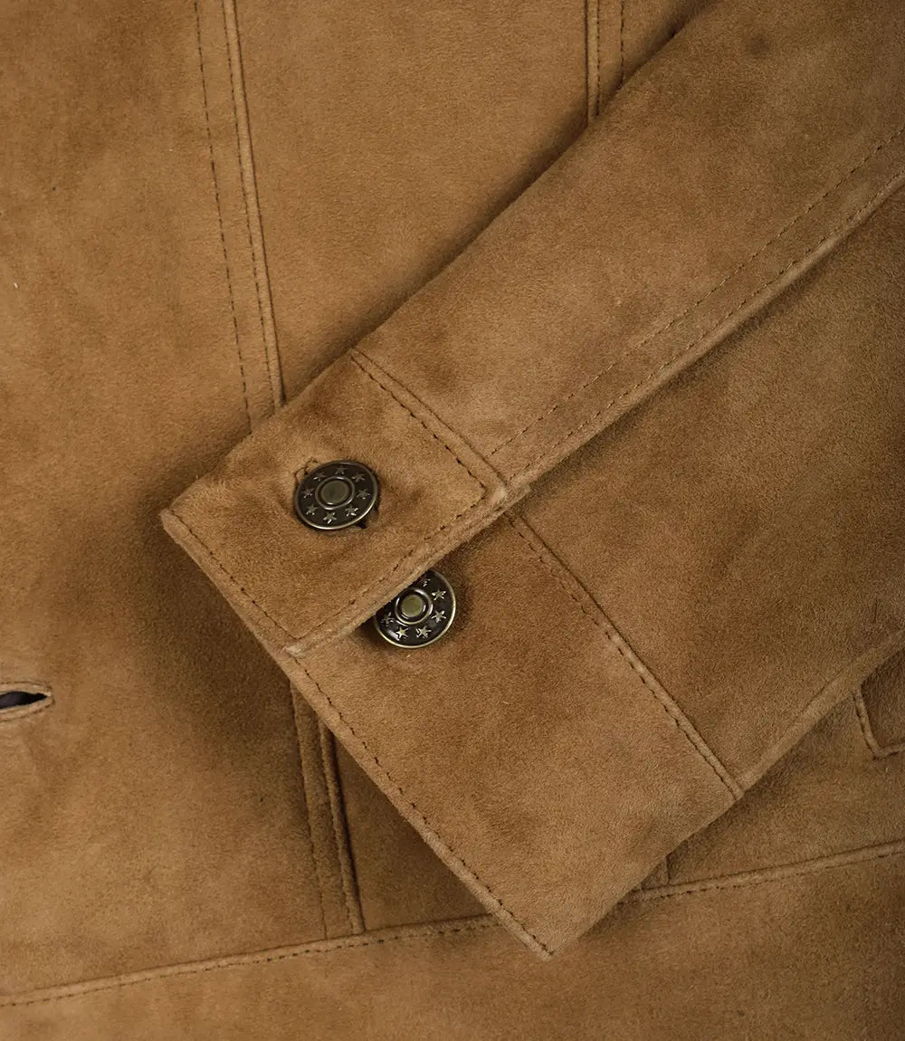 Detail van de knoopmanchetten en de verfijnde stiksels van de duurzame leren truckerjas in tan kleur.