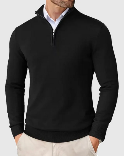 De zwarte sweater, opgevouwen op een tafel, benadrukt de zachte textuur en veelzijdigheid van de trui.